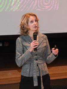 Middle aged white woman holding a microphone teaching professional develpment