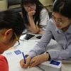 Three people collaborating on a project in a classroom.