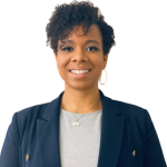 Headshot of Brianna: Younger black woman with short curly hair wearing a blue blazer and gray shirt