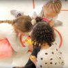 Group of three diverse kindergarten age girls learning in a group from above.