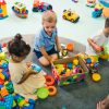 Diverse group of toddlers playing with blocks at a childcare center.