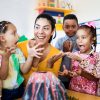 Female kindergarten teacher of color with diverse group of kindergarten students in a classroom