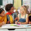 Diverse group of kindergarten students in a classroom working on an art project