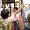 Group of diverse young preschool students in a circle holding hands in a classroom setting