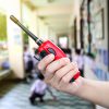 A person's hand holding a walkie-talkie.