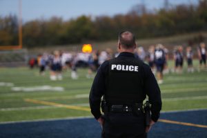 A police officer standing on a sports field.