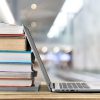 A stack of books and a laptop.