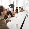 A group of people sitting at a conference room table.