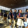 A group of students in uniform walking and smiling.