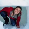 A person smiling in a tunnel of snow.