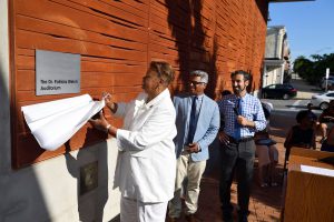 Patricia Welch reveals a sign on a building that says, "The Dr. Patricia Welch Auditorium."