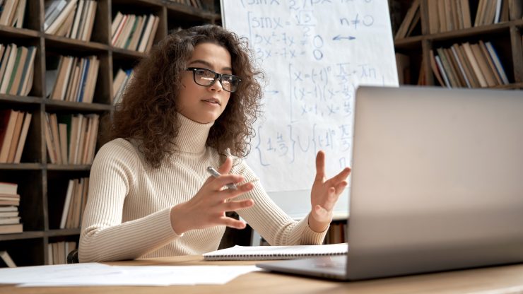 A person using a laptop and notebook.