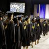 Graduates standing at a graduation ceremony.