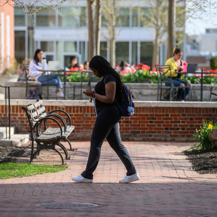 A student walking on the Johns Hopkins University Homewood campus.