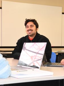 A person smiling in a classroom.