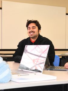 Three people sitting in a classroom.