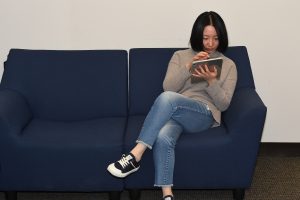A person sitting on a couch using a tablet.
