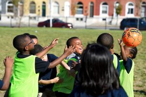 Children laughing and playing with a ball.