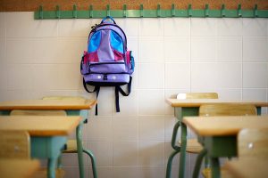 A backpack hanging in a classroom.