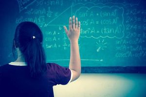 A child raising their hand in a classroom.