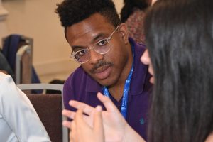 A person wearing a Johns Hopkins School of Education lanyard.