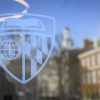 The Johns Hopkins shield on a window on the Johns Hopkins University campus.