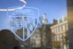 The Johns Hopkins shield on a window on the Johns Hopkins University campus.