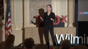 Ashley Berner standing and giving a TEDxWilmingtonED talk.