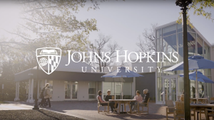 People outside with the JHU logo overlaid on the image.