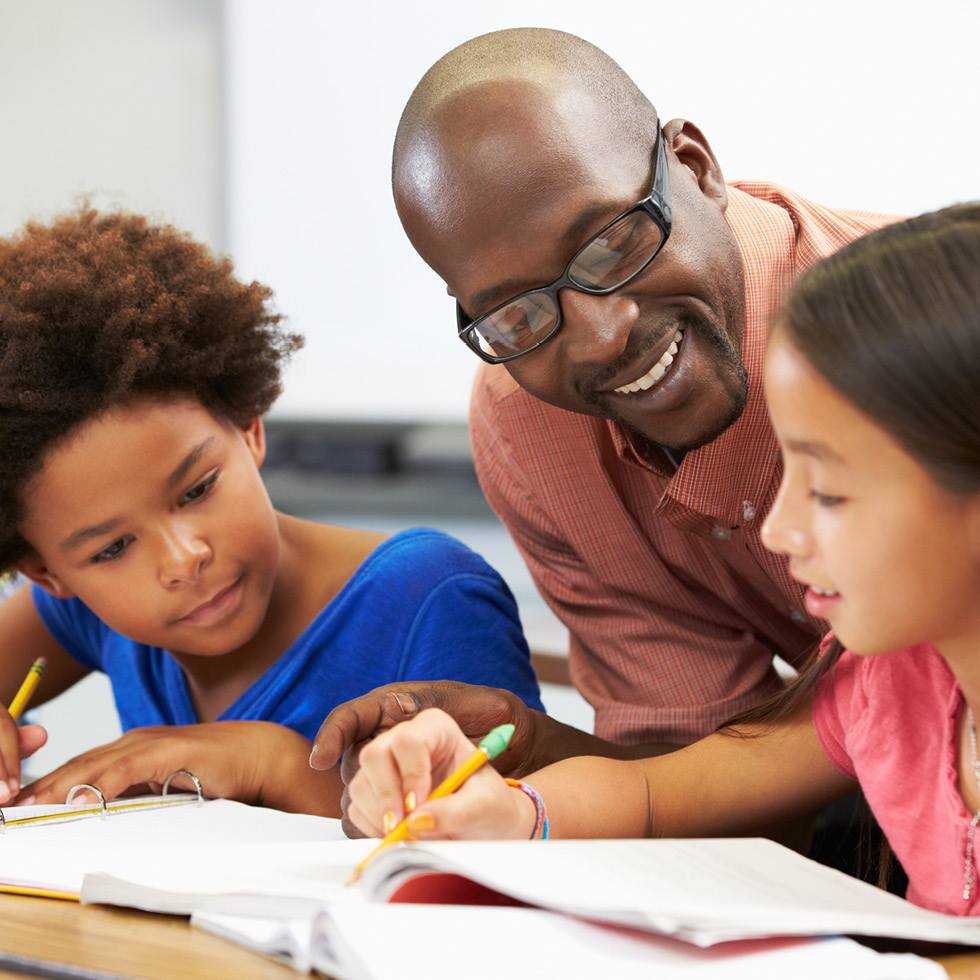 Three people looking at a workbook together.