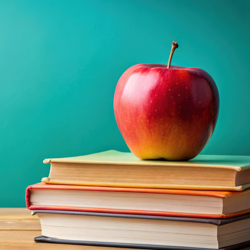 An apple sitting on top of a stack of books.