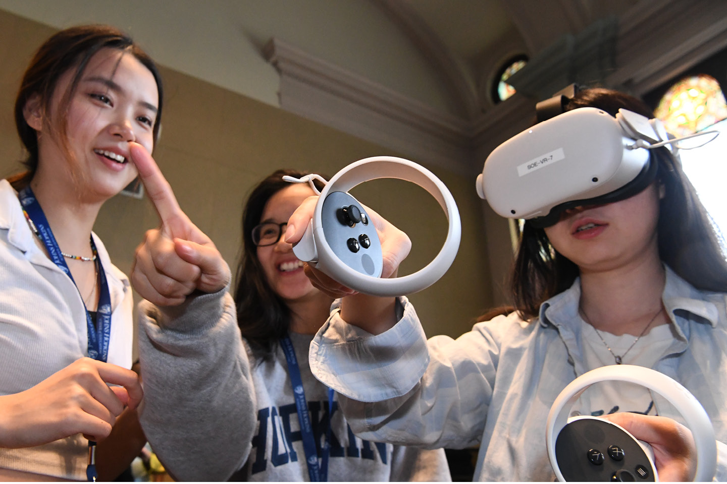 Three people experiencing a virtual reality headset.