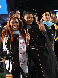 two graduates pose for the camera after the graduation ceremony