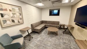 Several seating areas with a large screen mounted on the wall