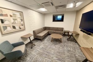 Several seating areas with a large screen mounted on the wall
