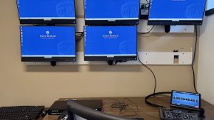 Five display screens mounted on a wall