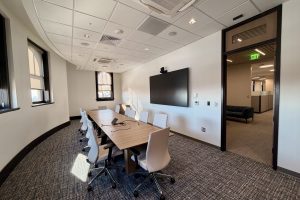 A conference room with a large table and several chairs