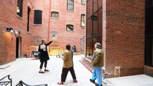 Three people in an outdoor brick courtyard