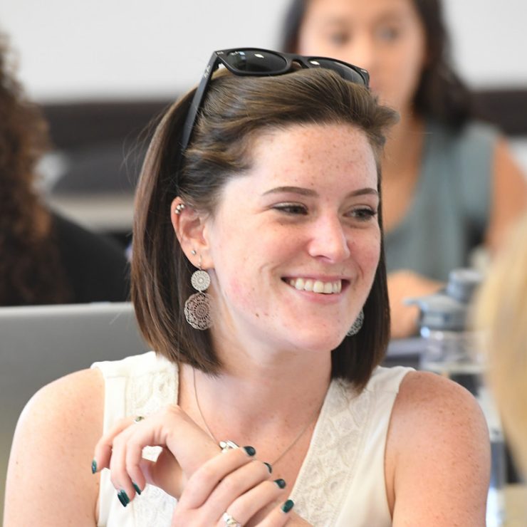 A person sitting in a classroom smiling